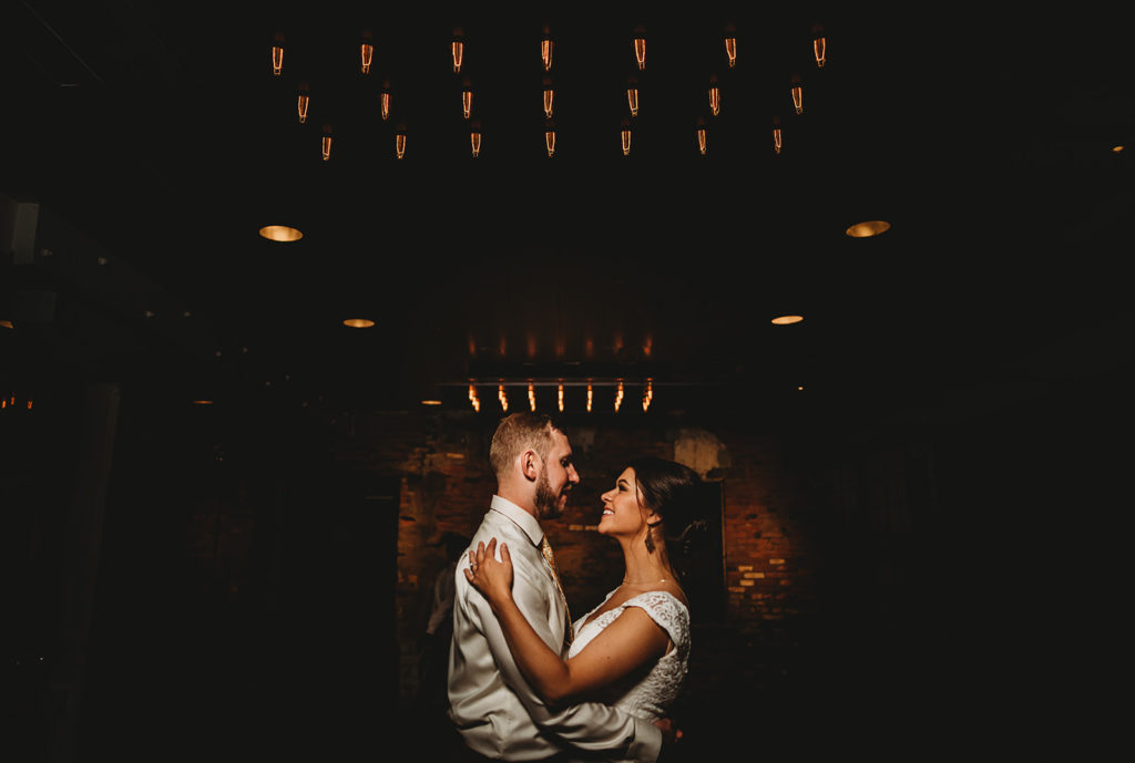 bride and groom slow dancing at the end of the night under twinkle lights captured by Baltimore wedding photographer