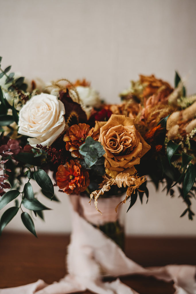 fall bridal bouquet for autumn wedding with white roses, orange florals and dark greenery for Baltimore wedding photos