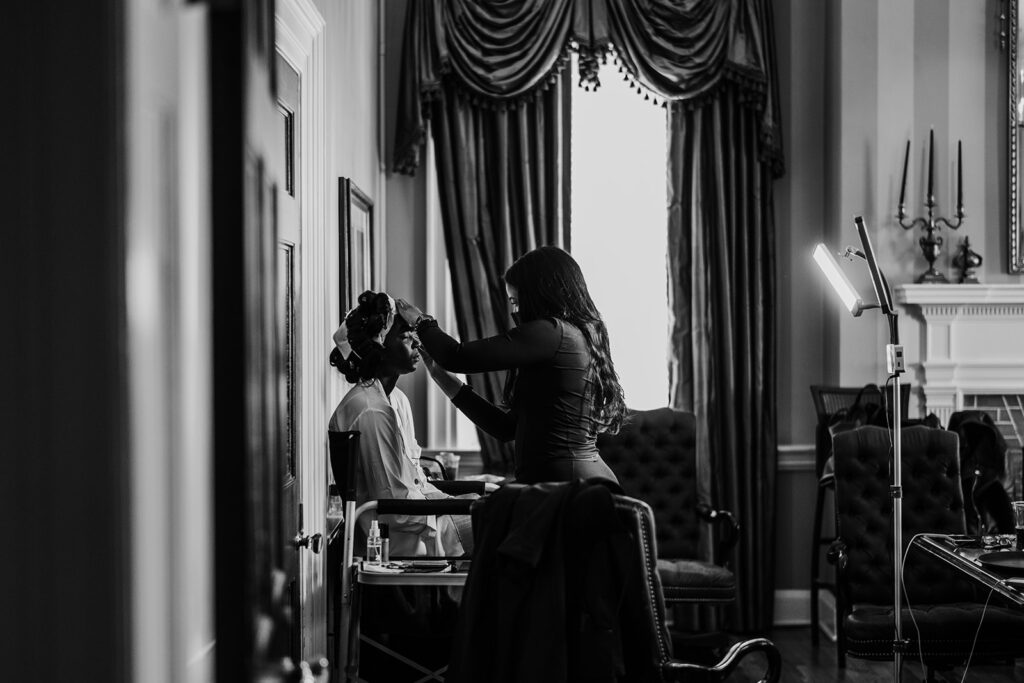 Bride getting her make up done in bridal suite of Belmont country club wedding
