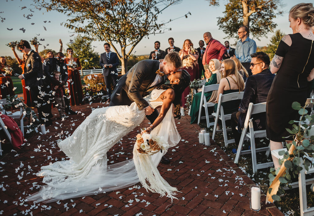 bride and groom exiting their wedding ceremony as their guests through floral on them at a Baltimore wedding venue with Maryland wedding photographer