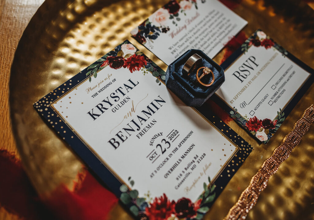 Detail shot of wedding invitations with blue and red details captured by Maryland wedding photographers