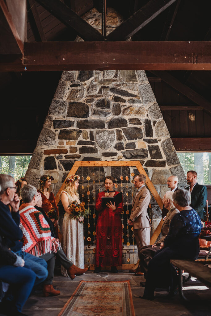 Maryland wedding photographer photographs bride and groom at the alter of their outdoor wedding venue in Maryland with moody fall decor