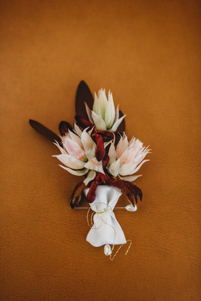 detail shot of grooms boutonniere on a orange background captured by Baltimore wedding photographers 