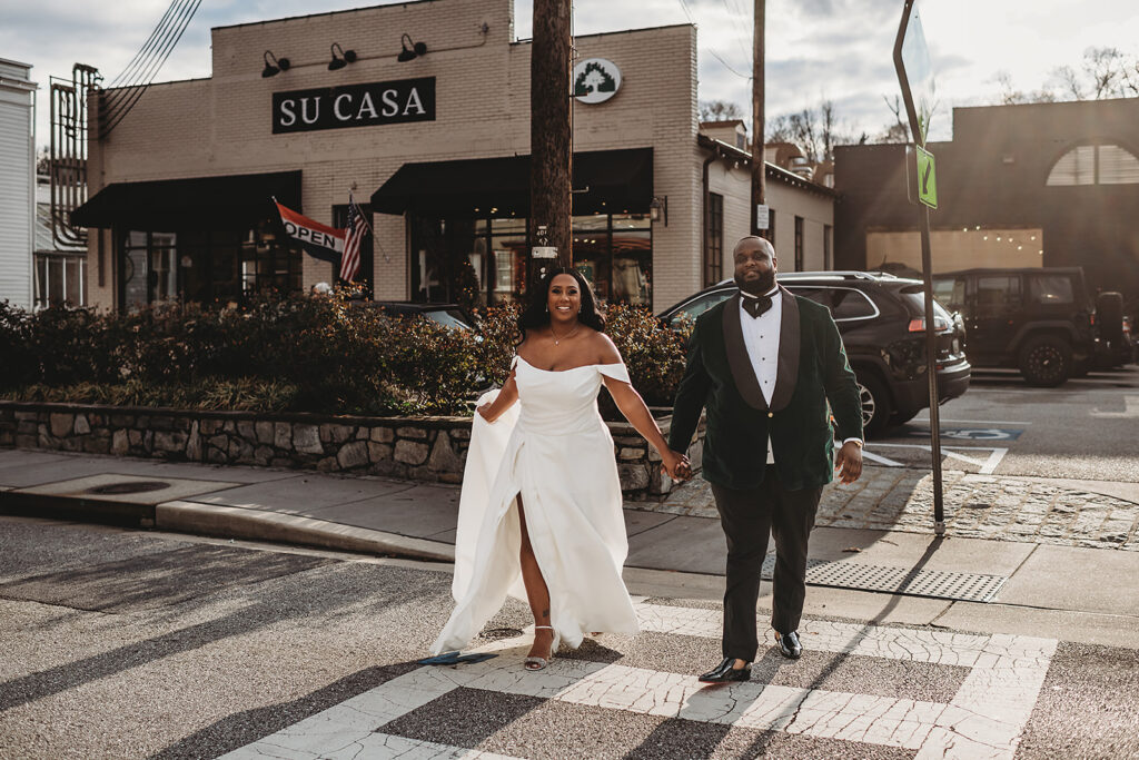 Baltimore photographers captured outdoor wedding portraits with bride and groom holding hands while walking across a cross walk in downtown Baltimore for their winter wedding