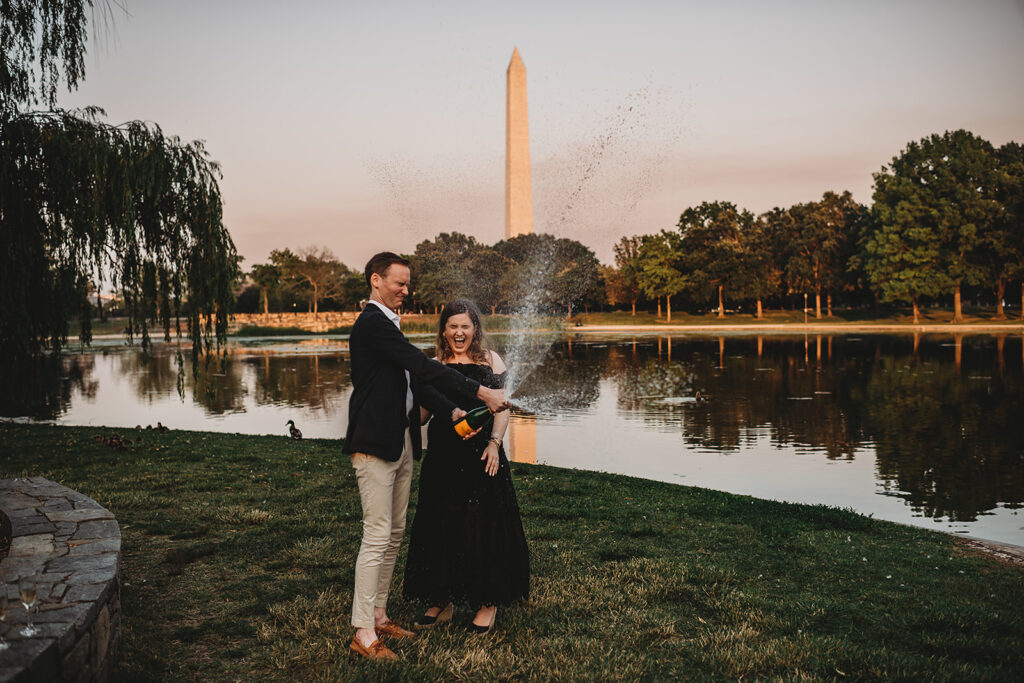 Baltimore photographers photographs man and woman popping the champagne together for their DC engagement pictures