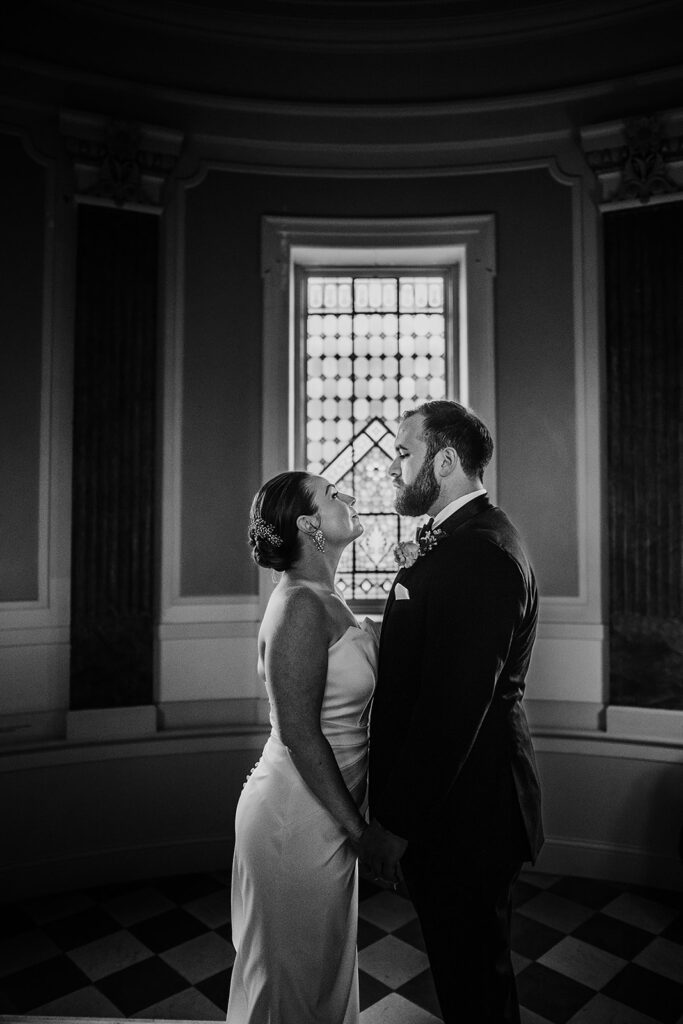 Baltimore wedding photographers capture bride and groom looking at one another during black and white bridal portraits