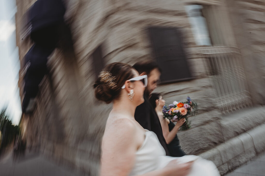 Baltimore wedding photographers capture bride and groom walking together wearing sunglasses after Riggs Hotel DC wedding