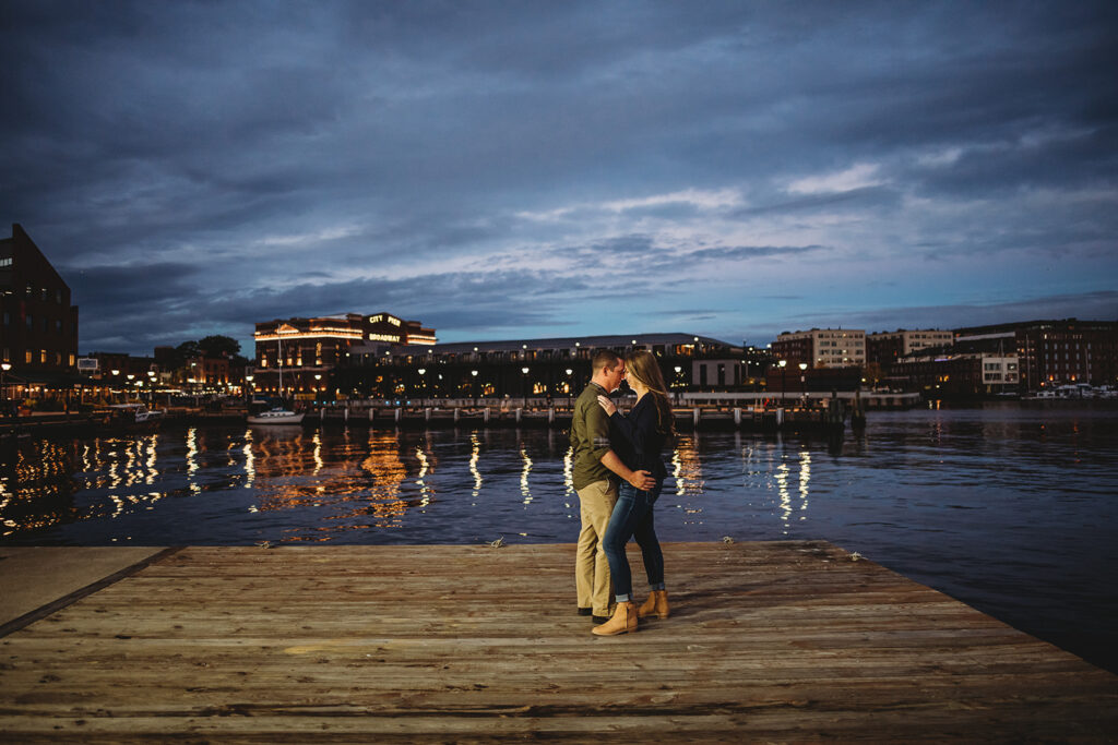 Baltimore wedding photographers capture man and woman at dock during Fells Point engagement photos