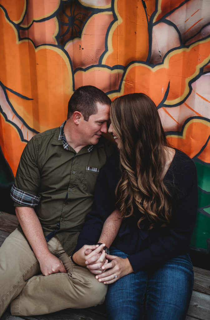 Baltimore wedding photographers capture couple with foreheads together in front of mural