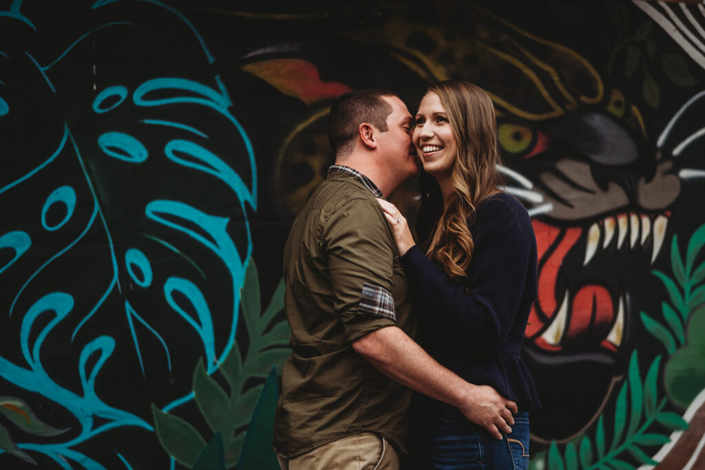 Baltimore wedding photographers captures man holding woman's waist and embracing during Fells Point engagement photos