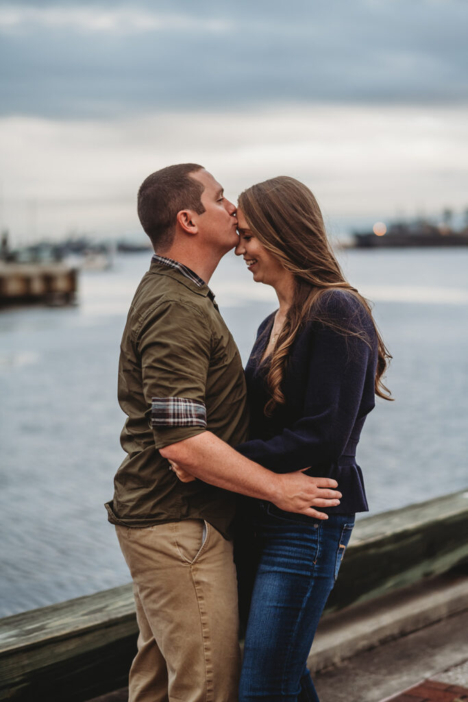 Baltimore wedding photographers capture man and woman embracing while man kisses woman's forehead