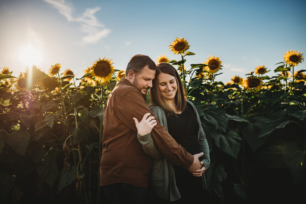 Baltimore photographers capture man and woman hugging during sunflower maternity photos