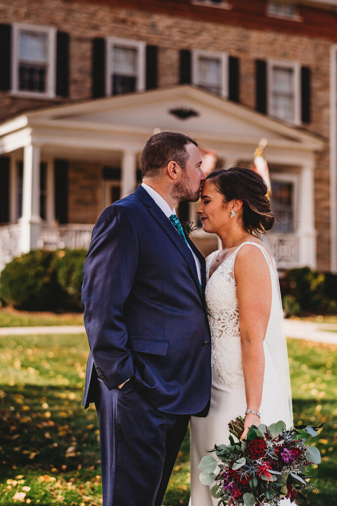 Baltimore wedding photographers capture groom kissing bride's forehead