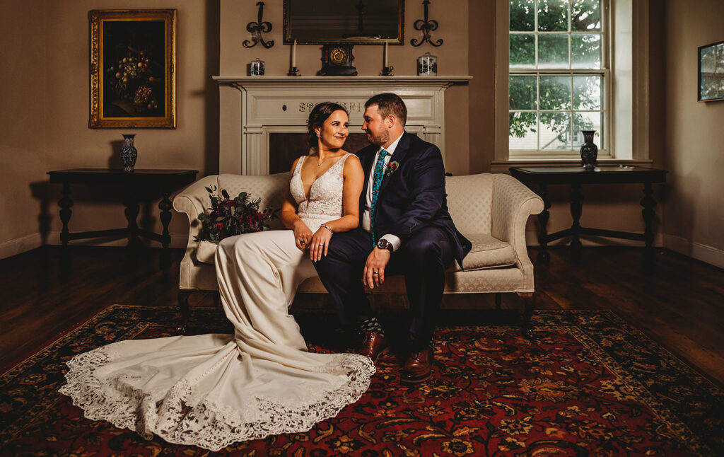 Baltimore wedding photographers capture bride and groom sitting on couch looking at one another