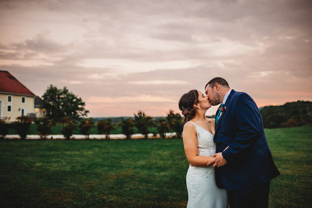 Baltimore wedding photographers capture couple kissing at sunset after Springfield Manor wedding