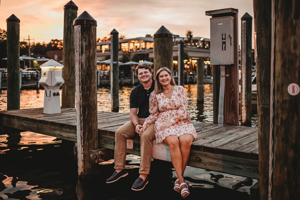 Baltimore wedding photographers capture couple sitting together on dock during Baltimore engagements