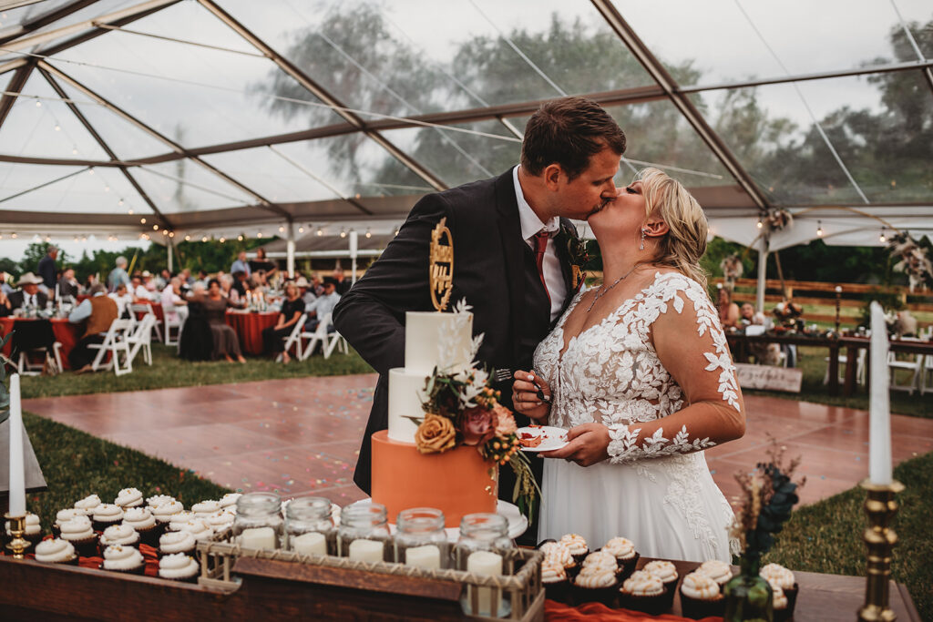 Maryland wedding photographer captures bride and groom kissing after cutting cake