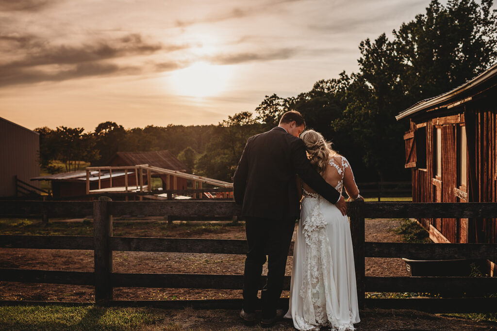 Maryland wedding photographer captures groom hugging bride at sunset