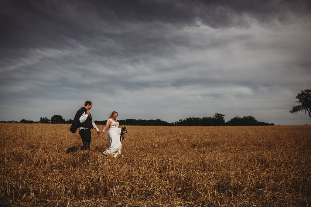 Maryland wedding photographer captures couple running through field together