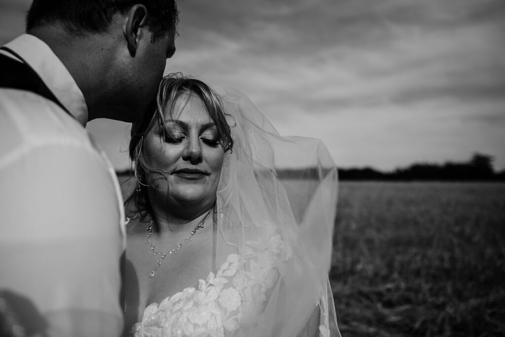 Maryland wedding photographer captures groom kissing bride's forehead in black and white portrait