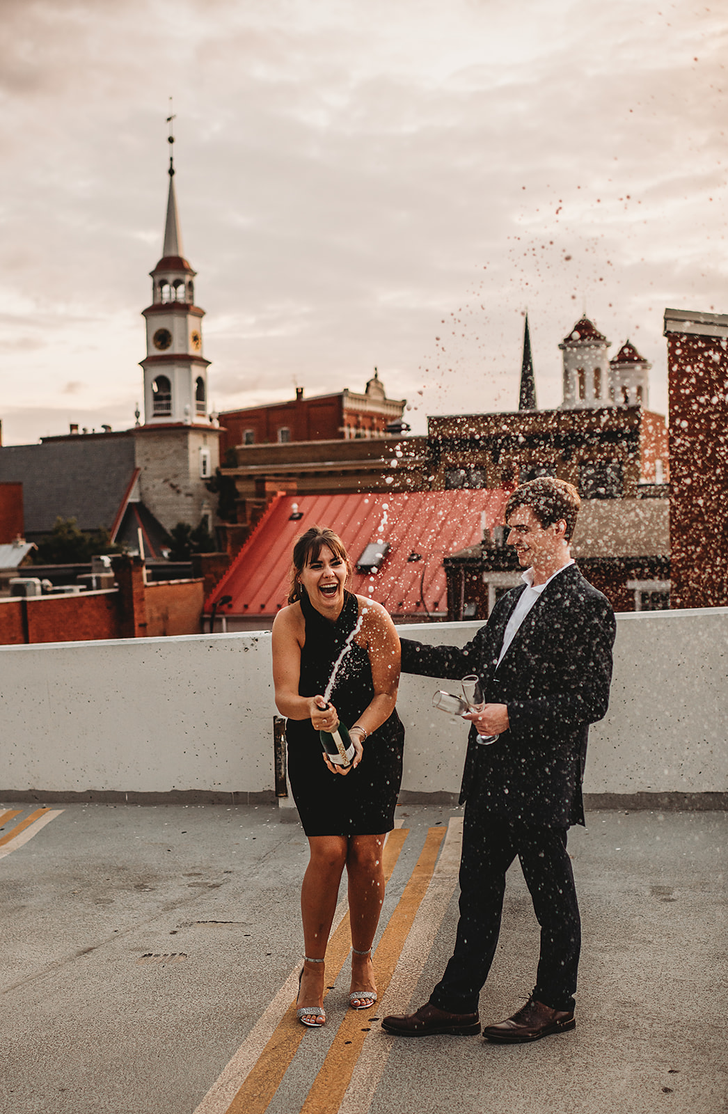 Maryland engagement photographers capture woman popping bottle of champagne to celebrate