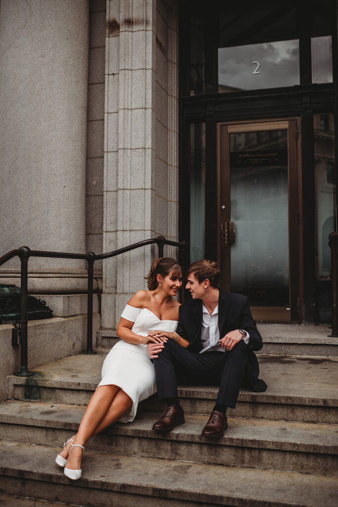 Maryland engagement photographers capture couple sitting on stairs laughing together during editorial engagement photos