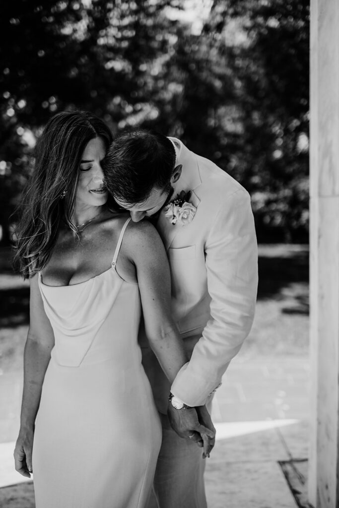 Baltimore wedding photographer captures black and white portrait of groom kissing bride's shoulder