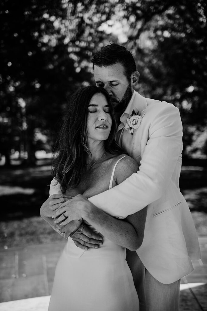 Baltimore wedding photographer captures black and white portrait of bride and groom embracing 