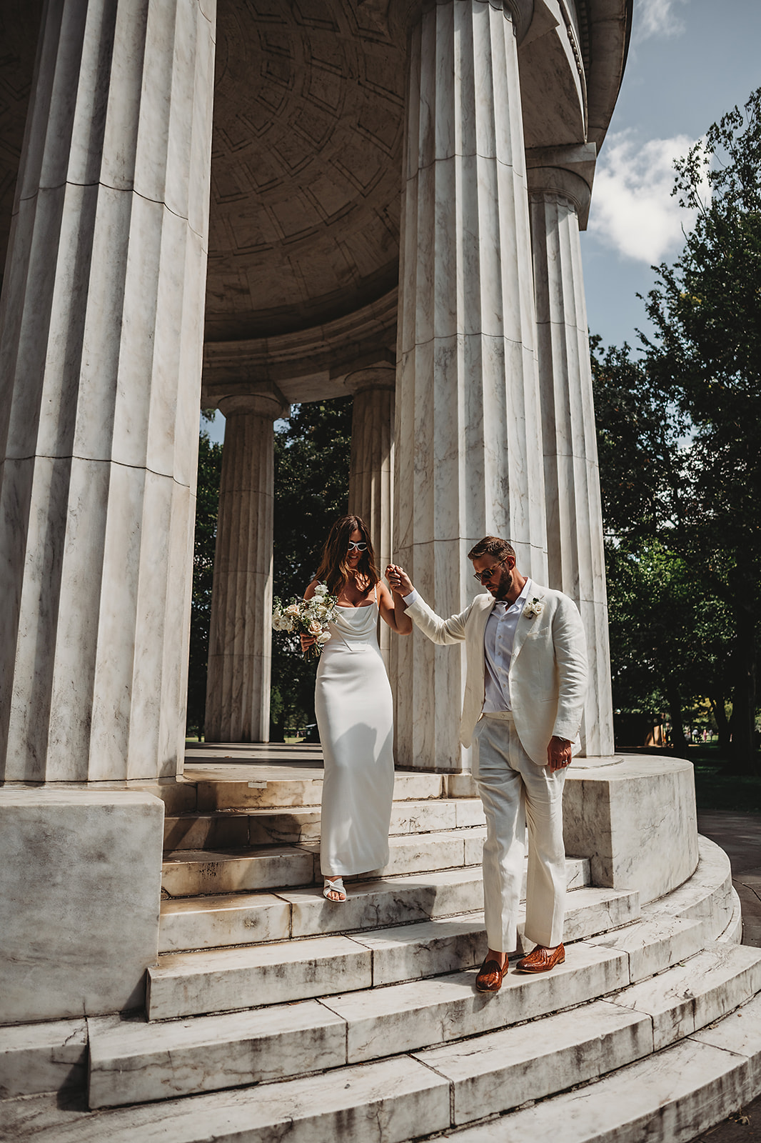 Baltimore wedding photographer captures groom leading bride down stairs during bridal portraits
