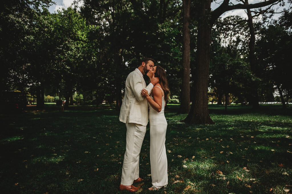 Baltimore wedding photographer captures couple kissing in front of greenery