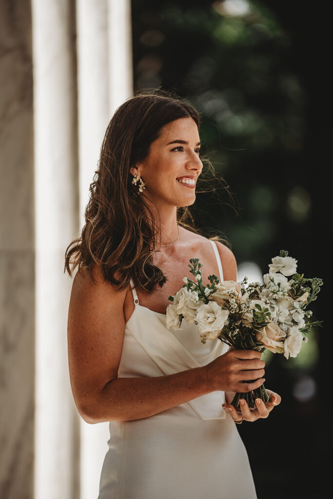 Baltimore wedding photographer captures bride holding bouquet looking at groom