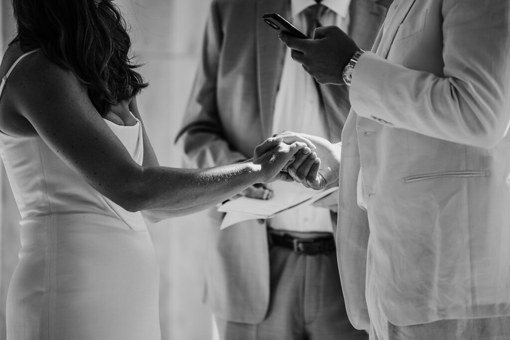 Baltimore wedding photographer captures groom reading vows while holding bride's hand