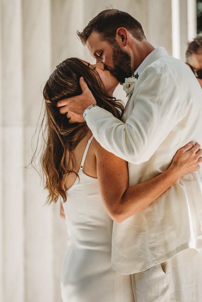 Baltimore wedding photographer captures groom kissing bride after ceremony
