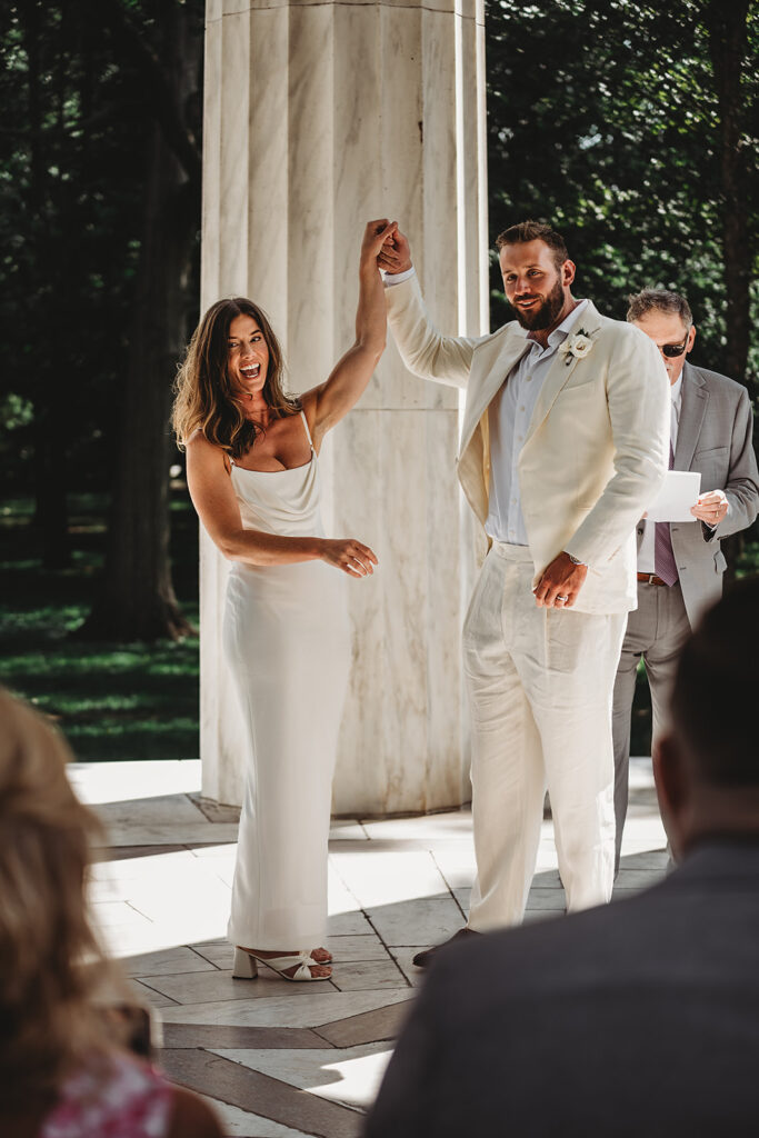 Baltimore wedding photographer captures bride and groom holding hands and celebrating recent marriage