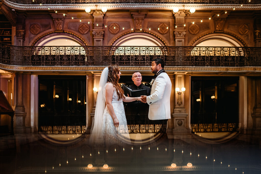 Baltimore wedding photographer captures bride and groom holding hands during ceremony