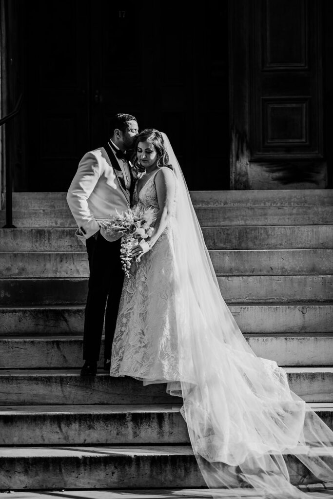 Baltimore wedding photographer captures bride and groom standing on steps during bridal portraits