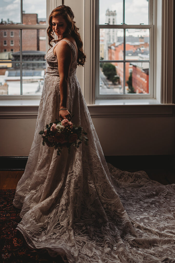 Baltimore wedding photographers capture bride holding bouquet and looking over shoulder
