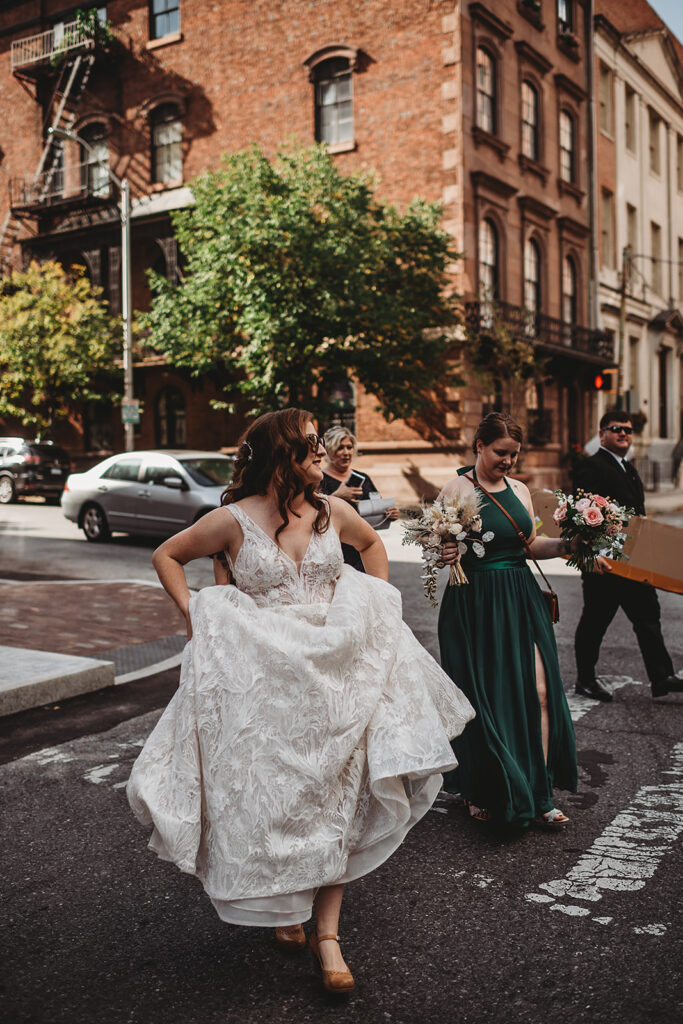 Baltimore wedding photographer captures bride holding wedding dress while walking