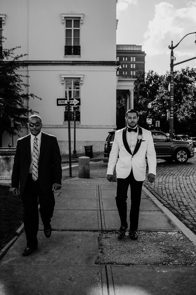 Baltimore wedding photographer captures black and white portrait of groom walking