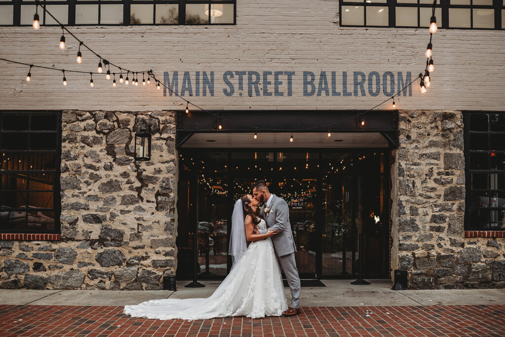 Maryland wedding photographer captures bride and groom kissing in front of venue