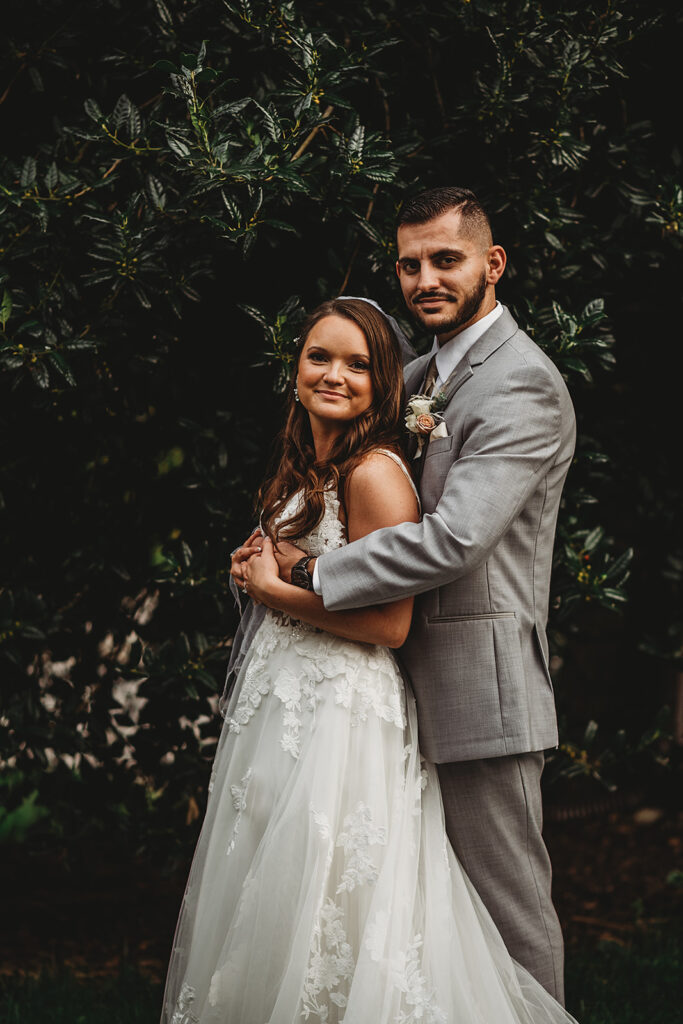 Maryland wedding photographer captures groom hugging bride during outdoor bridal portraits