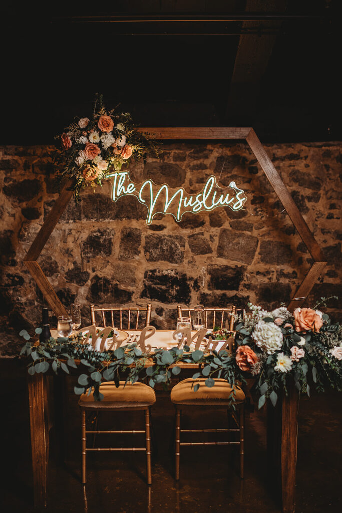 Maryland wedding photographer captures sweetheart table with arch and couple's name behind it