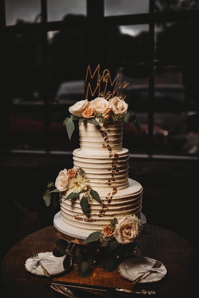 Maryland wedding photographer captures three tiered wedding cake with flowers throughout