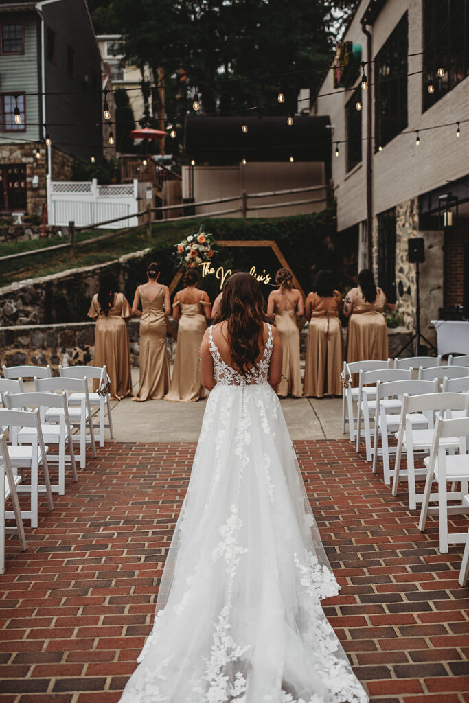Maryland wedding photographer captures bride walking down aisle before first look with bridesmaids