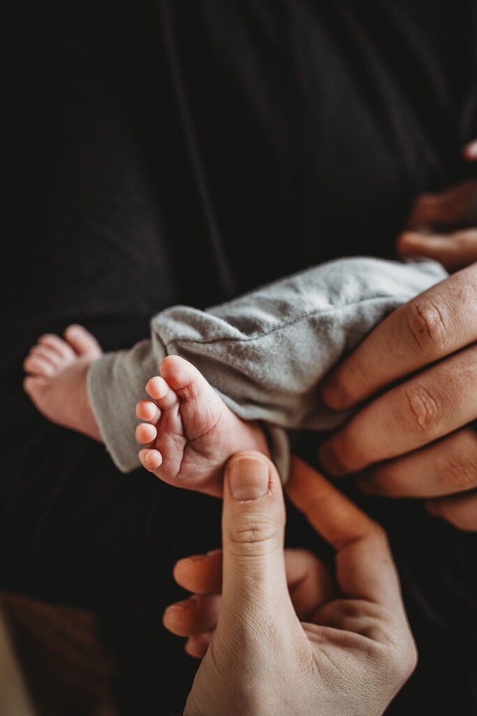 Baltimore photographers capture parents holding baby and touching toes