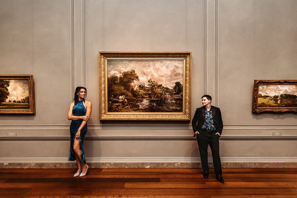 Maryland engagement photographer captures couple standing against wall in front of art