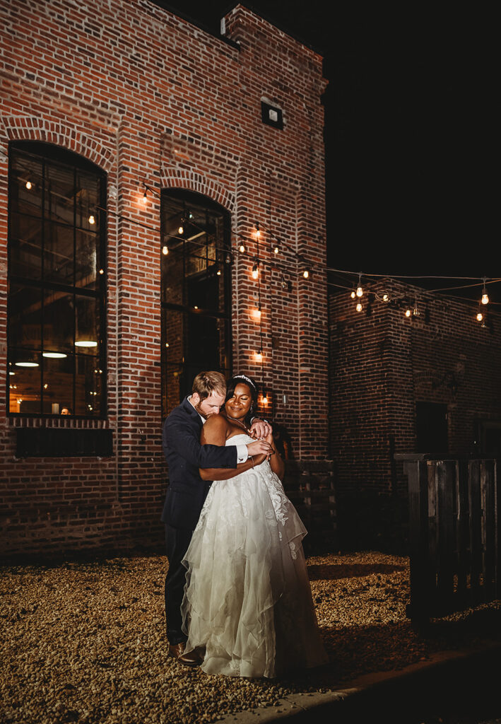 Baltimore wedding photographers capture bride and groom hugging outdoors during bridal portraits