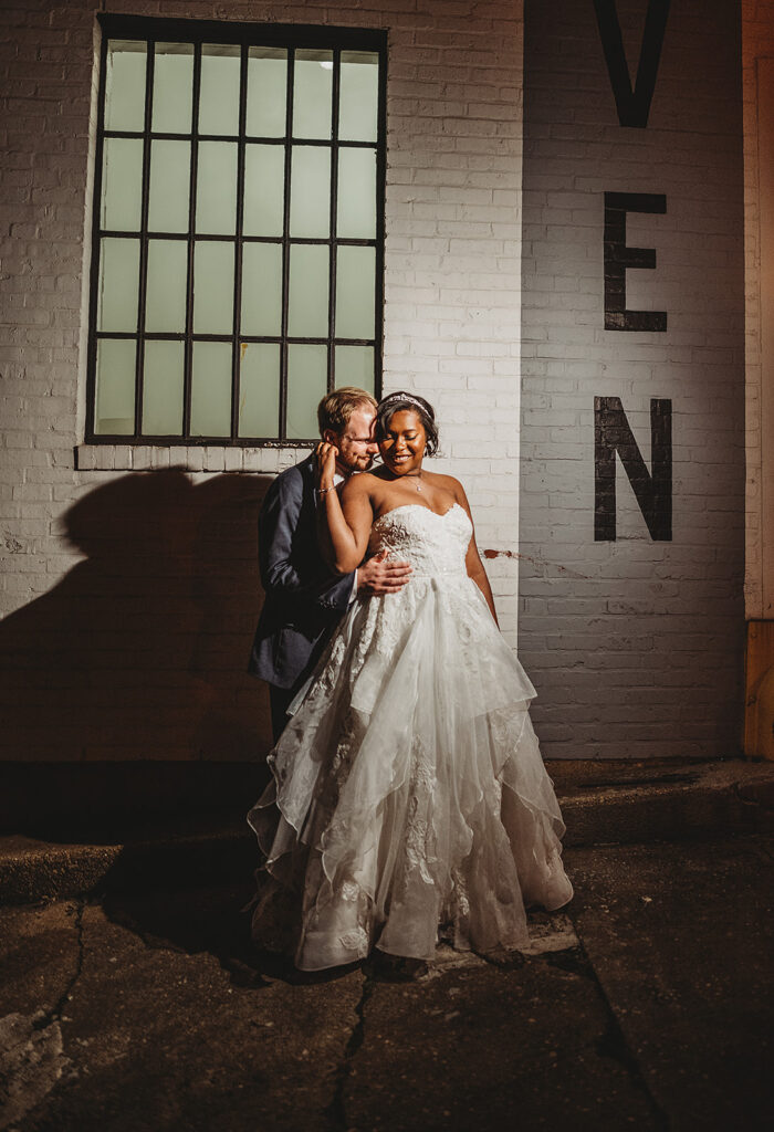 Baltimore wedding photographers capture groom hugging bride from behind during spotlight bridals
