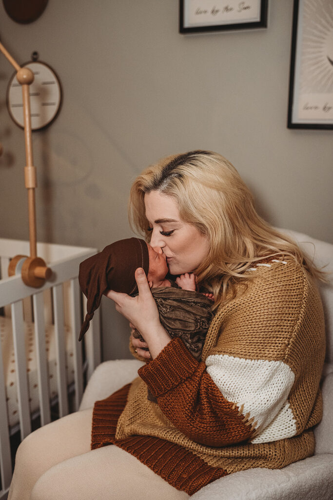 Baltimore photographers capture mother kissing baby during in home newborn photos