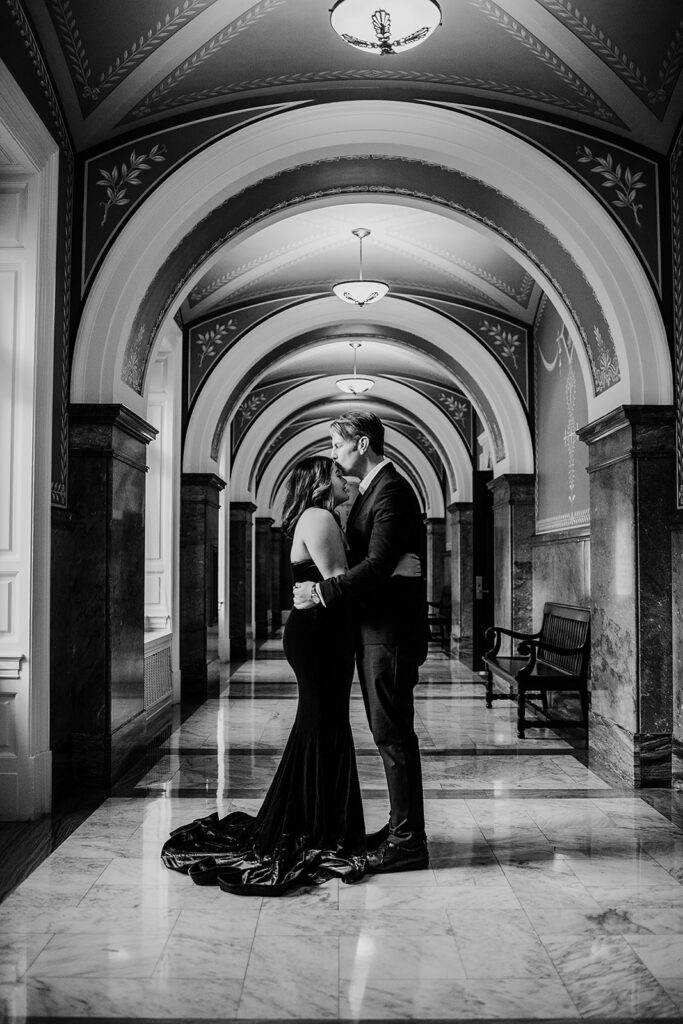 Baltimore wedding photographer captures bride and groom kissing in hallway wearing formal attire